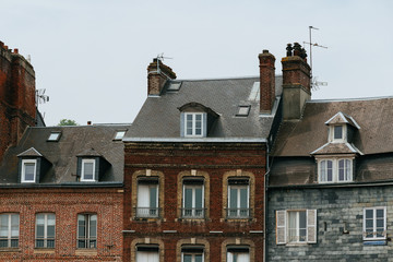 Facades of traditional residential houses in Honfleur, region of Normandy, France. Norman style old houses. Beautiful european cityscape with atmospheric streets and typical french architecture