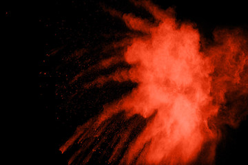 Red color powder explosion on black background.