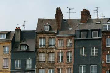 Facades of traditional residential houses in Honfleur, region of Normandy, France. Norman style old houses. Beautiful european cityscape with atmospheric streets and typical french architecture