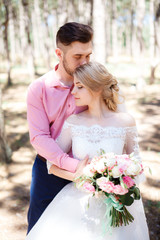 Happy wedding couple hugging and kissing. Beautiful young bride and groom, just married. Couple in love. Shallow focus and some noise.