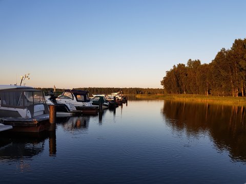 boats and yachts on the dock on the river at sunset © alinaait