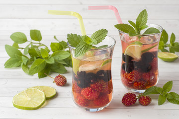Cocktail with black currant, strawberry, mint and lime. Cooling summer drink.