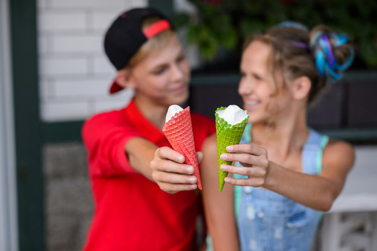 Young Couple Eating Ice Cream. Attractive Friends At Cafe. Romantic Love Moment Of Teenagers