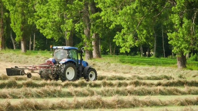 Tractor tending to a grass field on a farm in Barcelonnette, France.