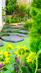 Stone walkway decoration in cozy home flower garden./ Stone walkway with flower pot and garden object decoration in cozy home flower garden on summer. 
