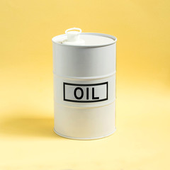 White barrel with oil on yellow background