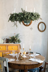 Round table with candles and nice tableware standing in middle of beautifully decorated room