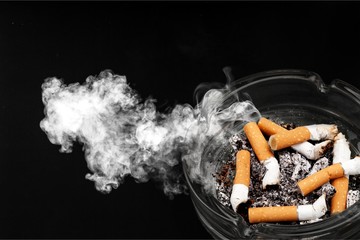 Ashtray and smoked cigarettes on backgrouund