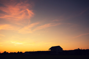 Rural landscape in evening at sunset. Silhouette of village against beautiful gradient evening sky