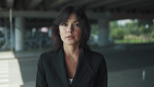 close-up portrait of a woman in a suit. the girl looks and after a while smiling at the camera
