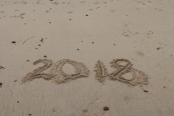 2018 written in the sand on the beach
