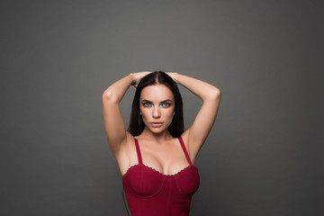 Fototapeta premium Beautiful woman with large breasts, natural make-up with beautiful long hair. Portrait of trendy, cheerful, modern, stylish, woman in eyewear isolated on grey background.
