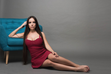 Closeup portrait of young beautiful woman with with beautiful long hair. Sitting and posing in studio. Portrait of trendy, cheerful, modern, stylish, woman in eyewear isolated on grey background.