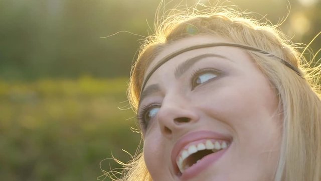 young blond woman with hippy papular portrait. Warm summer day and soft backlight. happy woman meditating at sunset. 4K