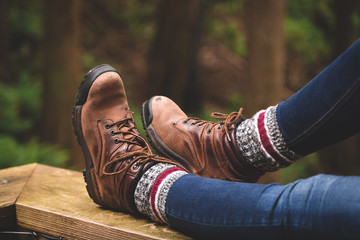 A rustic photo of hiking boots with a forest background.