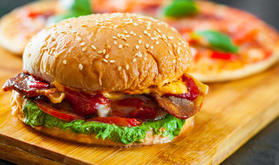 bacon cheese burger with beef patty tomato onion and Pizza with Mozzarella cheese, Ham, Tomatoes, salami, pepper, pepperoni Spices and Fresh Basil