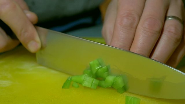 Man dicing celery with knife. Low angle close up