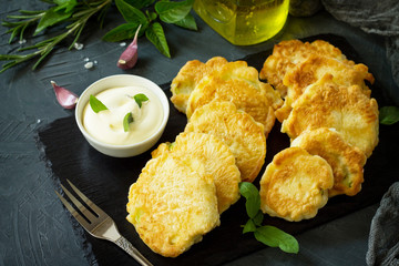 Vegan vegetable fritters on a background of slate cutting board. Fried vegetarian cutlets or pancakes. The concept of fast food.