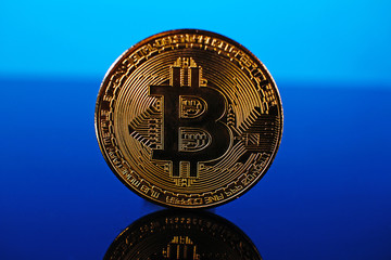 Bitcoin money crypto currency coin on reflective colorful background
