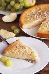 Homemade apple pie with nuts. Autumn food concept. Pie and fall fruits: apples, grapes and nuts.