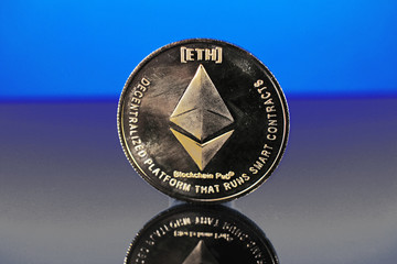 Etherum money crypto currency coin on reflective colorful background