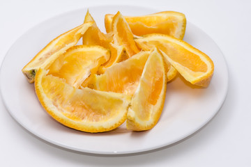 Fototapeta na wymiar Eaten slliced orange on white plate with white background and room for copy text