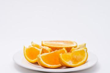 Fototapeta na wymiar Slices of orange on white plate with white background and room for copy text
