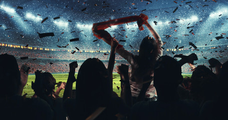Fans celebrating the success of their favorite sports team on the stands of the professional stadium while it's snowing - obrazy, fototapety, plakaty