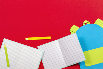 School education papercut background. School bag backpack, books notebooks school supplies paper cut on red background