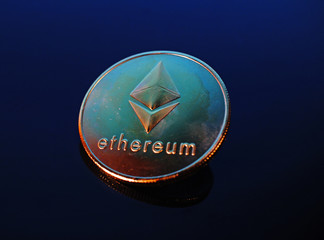 Etherum money crypto currency coin on reflective colorful background