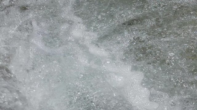 Beautiful water in a mountain river in slow motion video. Shooting speed 180fps, slow motion. Live shooting of the most beautiful nature river mountain water. The camera is static.