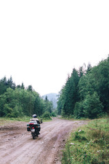 Motorcyclist man ride on Adventure Motorbike with beautiful mountains dirt road. Motorcycle trip. off road Traveling, Lifestyle Travel vacations sport outdoor concept vertical photo