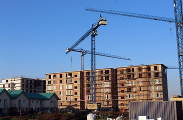 Large construction site including several cranes working on a building complex