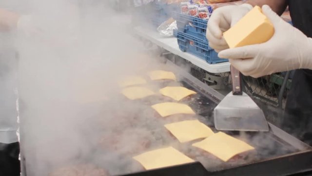 Man cooking burgers for homeless