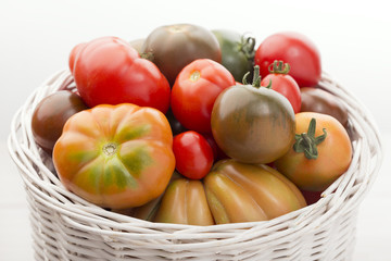 Basket of a organic tomatoes with white background