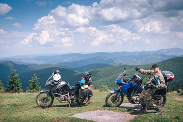 Happy Motorcyclist man and Adventure Motorbike on the top of mountains. Motorcycle trip. off road Traveling, Lifestyle Travel vacations sport outdoor concept.