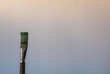 Old used paint brush on a light background with copy space