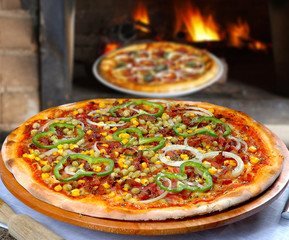 Pizza with corn, bacon, chili, onion, pea