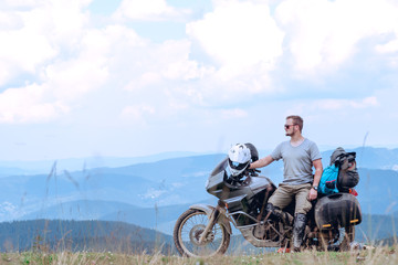 Obraz premium Motorcyclist man and Adventure Motorbike on the top of the mountain. Motorcycle trip. off road Traveling, Lifestyle Travel vacations sport outdoor concept.