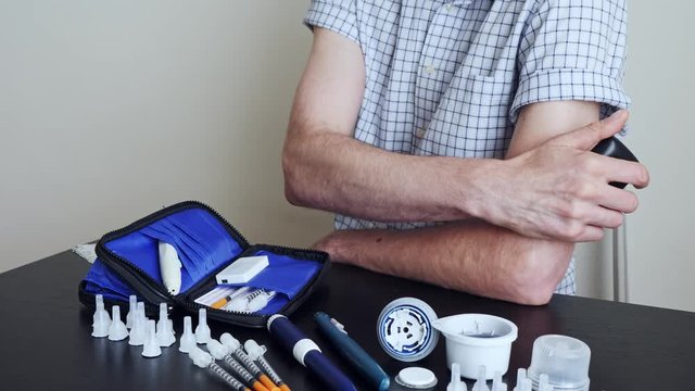 A man using a non-invasive glucose meter to measuring glucose level blood