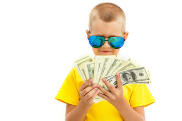 Portrait of a cheerful little boy holding a dollars over white background