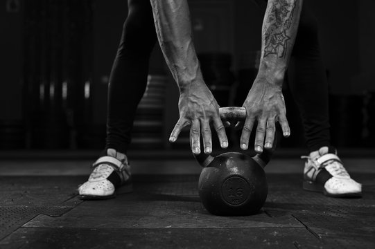 Close-up - male muscular athlete doing exercise with kettlebell. Sports, fitness concept.