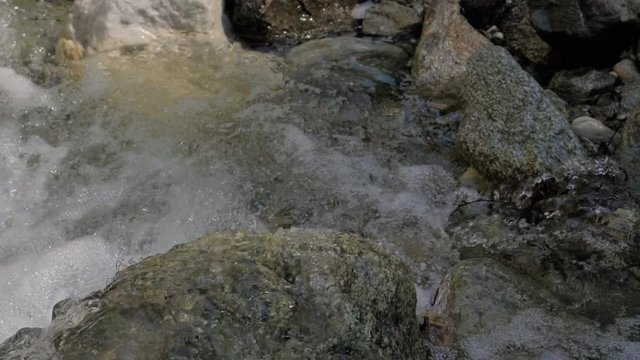 Beautiful water in a mountain river in slow motion video. Shooting speed 180fps, slow motion. Live shooting of the most beautiful nature river mountain water. The camera is not static.