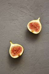Two halves of a fig on gray background, top view. Overhead, from above.