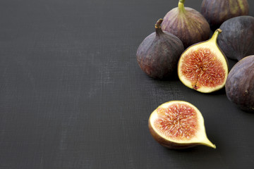 Fresh figs on dark surface, side view. Close-up. Copy space and text area.