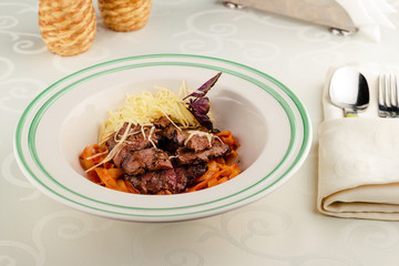 Tagliatelle with tail steak stripe and champignons with grated parmesan cheese. Copy space