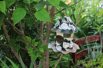 Beautiful park with many flowers. Secret garden. Chimney rock, NC, USA. Interesting and creative bird feeder in the form of a house made of green-white flowers. Landscaping