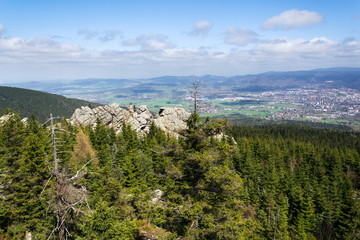 Rock formation Virive kameny - Whirling Stones under Jested mountain peak with Liberec city in background, Czech Republic, sunny summer day