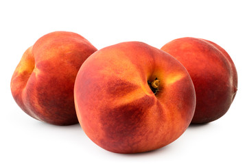 Three ripe peaches in close-up on a white. Isolated.