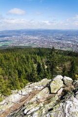 Fototapeta na wymiar Rock formation Virive kameny - Whirling Stones under Jested mountain peak with Liberec city in background, Czech Republic, sunny summer day